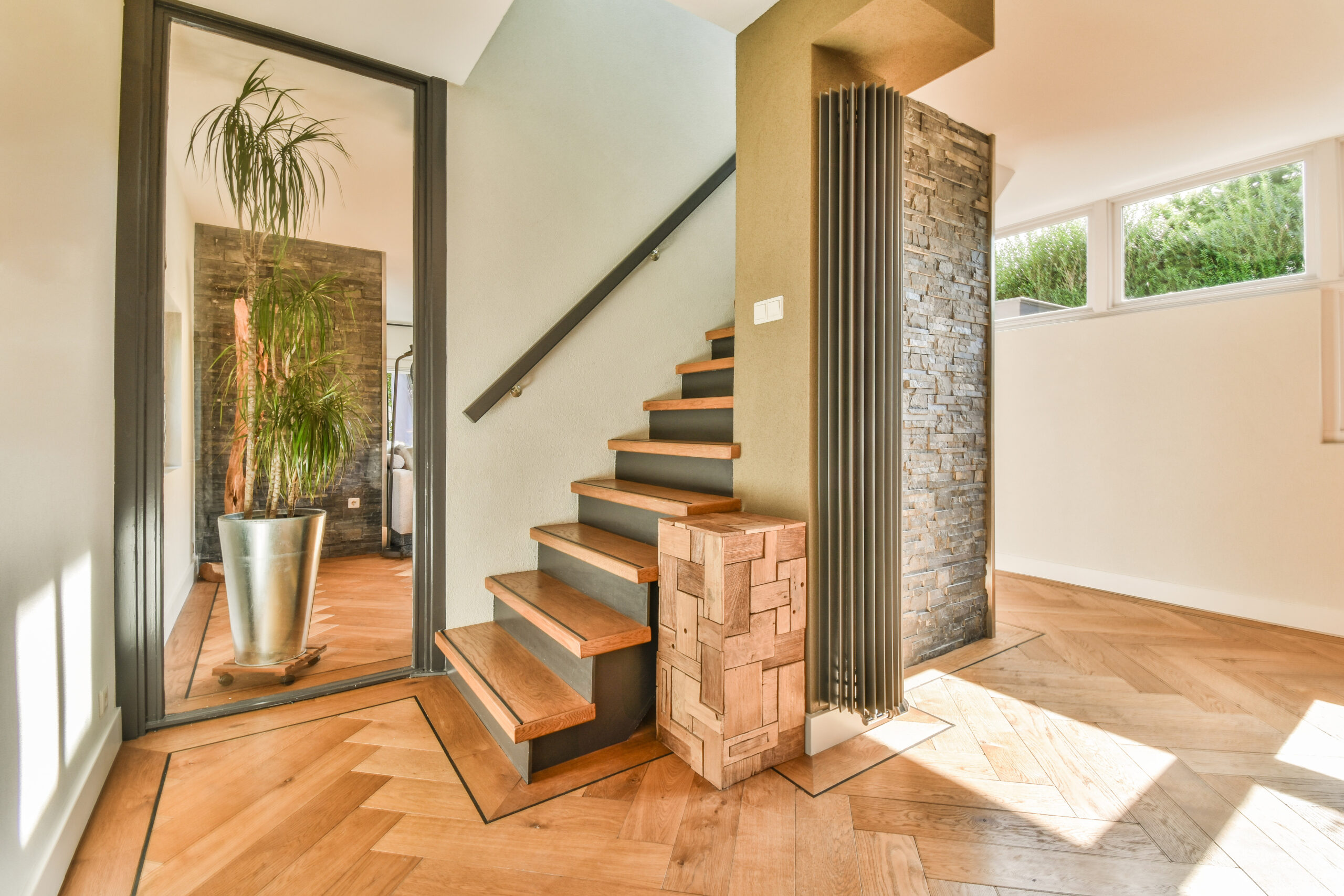 Wooden staircase in spacious hall of apartment